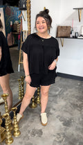 Woman in black outfit standing in a room with decorative elements